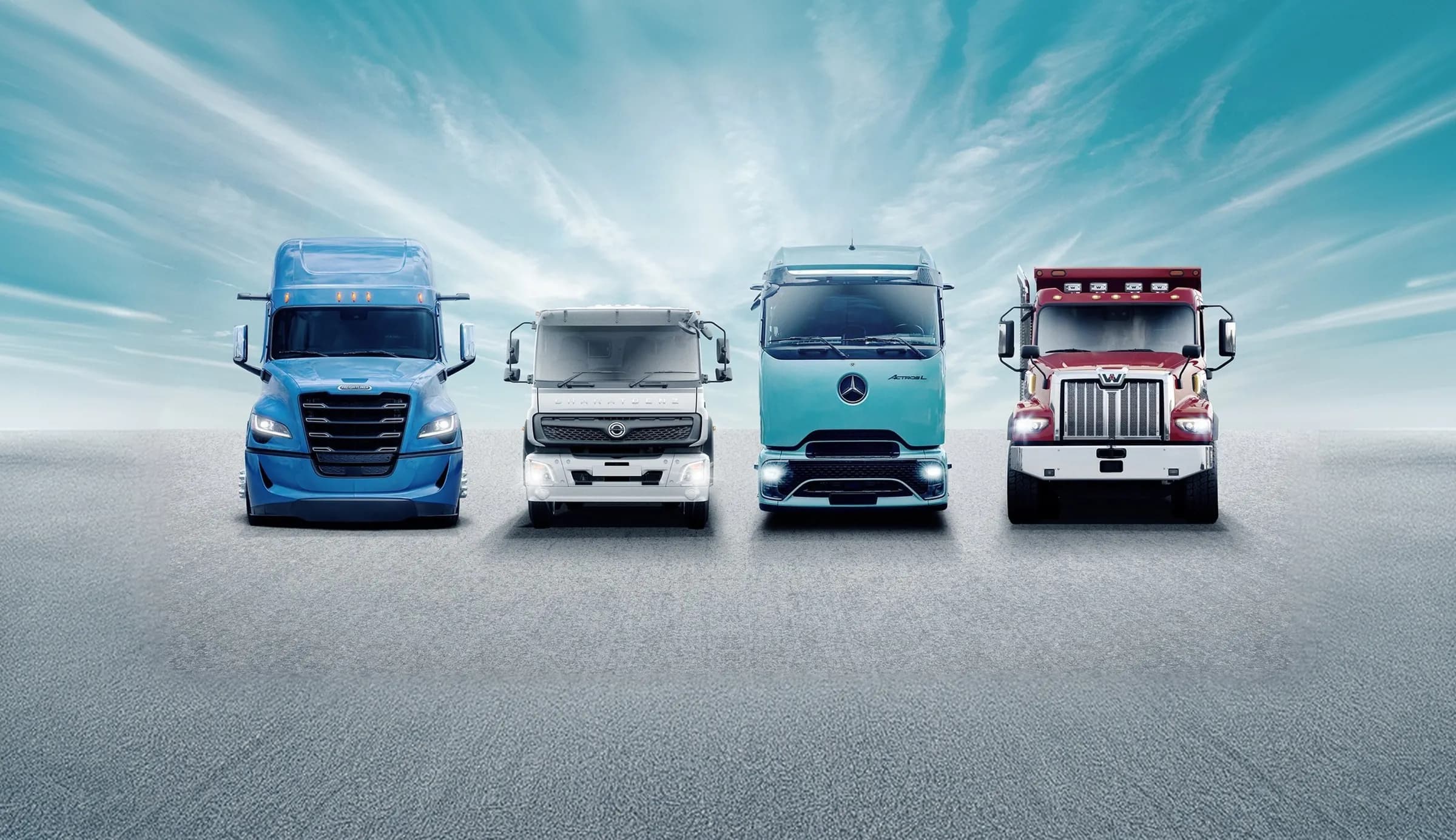 Four Daimler Truck brand vehicles lined up on a grey plane under a bright sky